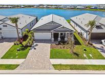 Overhead view of a well-maintained home with a brick driveway, surrounded by lush landscaping at 17441 Savory Mist Cir, Bradenton, FL 34211