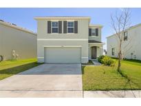 Charming two-story home with a two-car garage and well-manicured lawn at 30910 Penny Surf Loop, Wesley Chapel, FL 33545