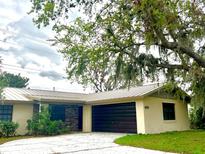 Charming single-story home with a metal roof, dark garage door, and stone facade detail at 3608 Oak Bark Ln, Brandon, FL 33511