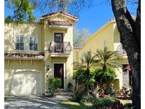 Charming two-story stucco home with a Spanish tile roof and landscaped front yard at 418 S Habana Ave, Tampa, FL 33609