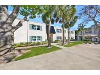 Inviting exterior view of the apartment complex with lush landscaping and beautiful palm trees at 4315 Aegean Dr # 130C, Tampa, FL 33611