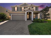 Charming two-story home with a well-manicured lawn and a paver driveway leading to a two-car garage at 4607 Ballantrae Boulevard, Land O Lakes, FL 34638