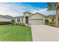 Charming single-story home featuring a two-car garage, manicured lawn, and a welcoming, landscaped front yard at 4712 Trout River Xing, Ellenton, FL 34222