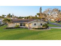 Charming single-story home with well-maintained lawn, mature trees, and a welcoming front entrance at 111 22Nd St, Belleair Beach, FL 33786