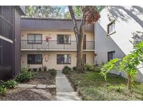 Two-story condo featuring exterior walkway access and well-maintained landscaping, providing a welcoming outdoor aesthetic at 11706 Raintree Village Blvd # D, Temple Terrace, FL 33617