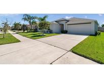 Charming single-story home with a well-manicured front yard and spacious driveway at 1615 Redmond Brook Ln, Ruskin, FL 33570