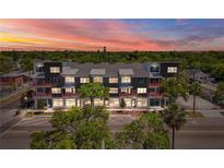 Modern multi-story condo building with red railings and professional landscaping under a colorful sunset sky at 15 29Th N St # Lot 7, St Petersburg, FL 33713