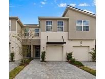 Attractive townhome with a well-maintained brick driveway and integrated garages at 4212 Cloud Hopper Way, Lutz, FL 33559