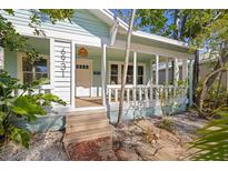 Charming home features a cozy front porch, verdant landscaping, and decorative exterior lighting at 6931 3Rd N St, St Petersburg, FL 33702