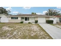 Charming single-story home features a well-maintained lawn, neutral paint, and an attached garage at 7740 Bracken Dr, Port Richey, FL 34668