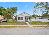 Charming home featuring a clean exterior with a well-manicured lawn and inviting front porch at 1001 Newton S Ave, St Petersburg, FL 33705