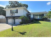 Charming two-story home with a well-manicured lawn, two-car garage, and beautiful landscaping at 13548 Bellewood Ave, Seminole, FL 33776