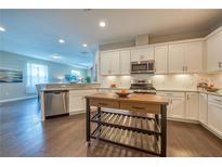 Bright kitchen features white cabinets, stainless steel appliances, granite countertops, and a functional island at 2012 Sidney St, Clearwater, FL 33763