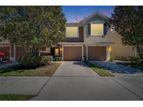 Charming two-story townhome featuring an attached two-car garage and a neatly landscaped front yard at 2128 River Turia Cir # 2128, Riverview, FL 33578