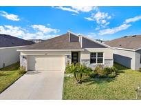 Charming single Gathering home with a well-manicured lawn and a two car garage in a suburban community at 31879 Treasure Dock Isle, Wesley Chapel, FL 33545