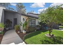 Charming home featuring meticulous landscaping, stone accents, and a welcoming walkway leading to the entrance at 6395 Pinestand Ct, Spring Hill, FL 34606