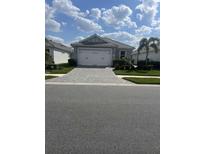 Charming single-story home with a two-car garage, manicured lawn, and a paved driveway at 953 Crosswind Ave, Sarasota, FL 34240