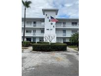 Charming condo with manicured landscaping, featuring a prominent building number and an American flag at 11201 80Th Ave # 305, Seminole, FL 33772
