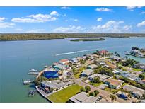 A scenic aerial view of waterfront homes on a tranquil bay with lush surroundings and boats cruising by at 330 176Th Avenue Cir, Redington Shores, FL 33708