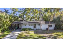 Charming one-story home featuring a covered carport, a stone walkway, and mature landscaping in the front yard at 4624 W Lamb Ave, Tampa, FL 33629