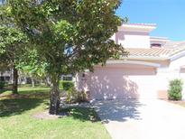 Charming home with a light-pink exterior and a well-manicured lawn at 829 Lantern Way # 829, Clearwater, FL 33765