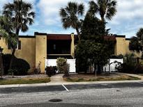 Inviting condo featuring a private balcony, neutral stucco facade, privacy fence, and tropical landscaping at 105 S Obrien St # 216, Tampa, FL 33609