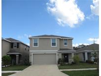 Two-story home with a two-car garage, neutral exterior, and well-manicured front lawn at 12178 Lily Magnolia Ln, Riverview, FL 33569