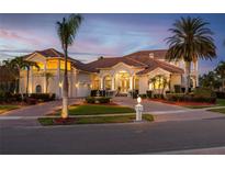 Elegant two-story home with lush landscaping, beautiful architectural details and a brick driveway at 1314 Jumana Loop, Apollo Beach, FL 33572