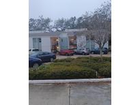 Multi-Gathering two-story residential complex with parking area, landscaping, and stairway access at 3801 N Oak Dr # A62, Tampa, FL 33611