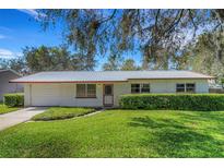 Charming single-story home with a metal roof, a lush green lawn, and a well-maintained brick facade at 4814 Edmund Ct, Dover, FL 33527