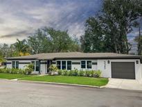 Charming single-story home with a gray roof, well-maintained lawn, and attached garage at 525 Lamara Ne Way, St Petersburg, FL 33704