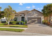 Charming single-story home with a well-manicured lawn, brick driveway, and a two-car garage at 9708 Highland Park Pl, Palmetto, FL 34221
