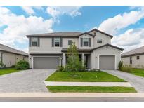 Two-story home with gray siding, two-car garage, well-manicured lawn, and neatly paved driveway at 15041 Sea Salt Way, Bradenton, FL 34211