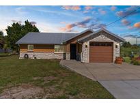 Charming single-story home with stone accents, metal roof, well-manicured lawn, and inviting curb appeal at 3609 Flamingo Blvd, Hernando Beach, FL 34607