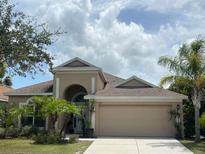 Charming single-story home featuring a well-maintained lawn and a spacious two-car garage at 5229 Clover Mist Dr, Apollo Beach, FL 33572