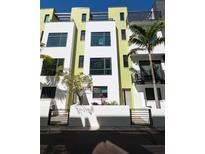 Modern townhome with gated entry, vibrant colors, and lush landscaping, embodying contemporary urban living at 923 Arlington N Ave, St Petersburg, FL 33705