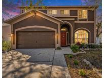 Charming two-story home with a well-manicured lawn, a two-car garage, and a welcoming red front door at 12705 Longcrest Dr, Riverview, FL 33579