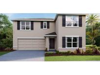 Charming two-story home features a two-car garage, neutral stucco exterior, and well-manicured lawn at 1706 Tahitian Sunrise Dr, Plant City, FL 33565
