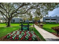 Beautiful condo community with lush landscaping, mature trees, and attractive multi-story buildings at 36750 Us Highway 19 N # 3-210, Palm Harbor, FL 34684