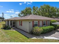 Charming single-story home features red shutters, a well-maintained lawn and walkway, and a cozy screened porch at 407 Feltham Trl # A, Sun City Center, FL 33573