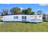 Charming single-story home with white painted brick, decorative trim, and well-maintained lawn at 5712 Mallow St, New Port Richey, FL 34652