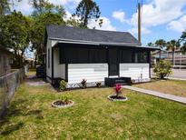 Charming house featuring a screened-in front porch and a well-maintained front lawn at 710 Seminole, Clearwater, FL 33755