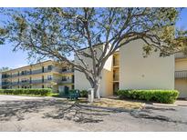 Well-maintained condo complex featuring mature landscaping, assigned parking, and inviting walkways at 14130 Rosemary Ln # 5206, Largo, FL 33774