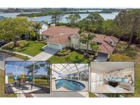 Stunning waterfront home with tile roof, lush landscaping, and beautiful views of the bay at 2005 N Pointe Alexis Dr, Tarpon Springs, FL 34689