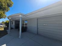 Charming exterior view with a covered front porch featuring decorative columns and a single-car garage at 3136 Primrose Dr, Holiday, FL 34691