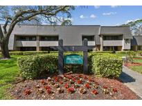 Inviting condo exterior with manicured landscaping, sign, and traditional architectural details at 36750 Us Highway 19 N # 01205, Palm Harbor, FL 34684