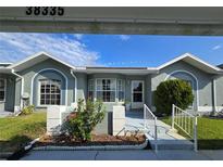 Charming exterior view with arched windows, tidy landscaping, and a welcoming entrance under a bright blue sky at 38339 Eucalyptus Dr, Zephyrhills, FL 33542