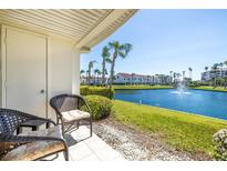 Relaxing balcony view with wicker chairs overlooking a tranquil lake with palm trees in a desirable community at 6061 Bahia Del Mar Blvd # 112, St Petersburg, FL 33715