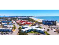 Beautiful aerial view of a bright white condo complex next to a white sandy beach at 7050 Sunset Way # 26, St Pete Beach, FL 33706