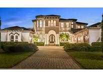 Elegant two-story home featuring a well manicured lawn, symmetrical shrubbery and circular tower design at 16312 Palmettoglen Ct, Lithia, FL 33547